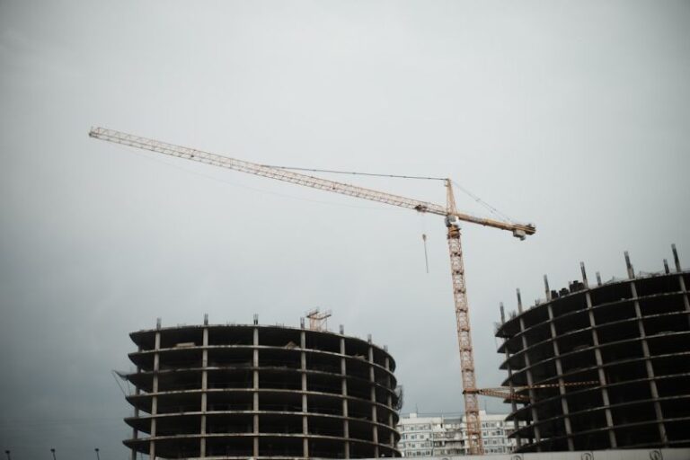 Building Process - yellow crane near black building