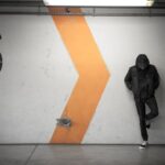 Urban - man leaning on white wall of the parking area