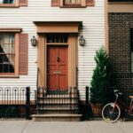 Urban House - red bicycle parked beside black metal gate in front house