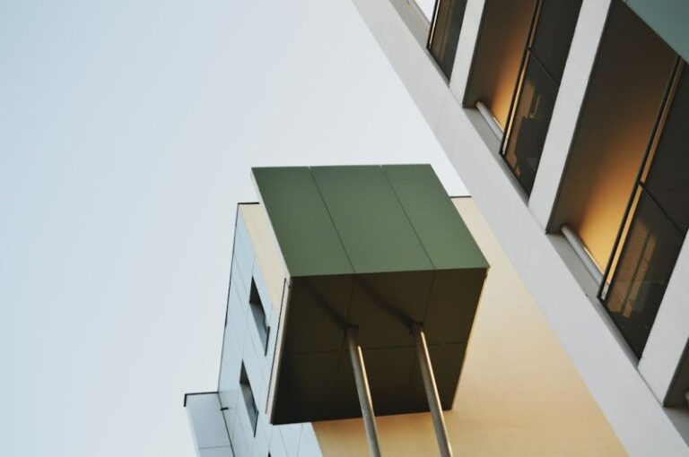 Contemporary Buildings - a tall building with windows and a green roof