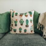 Interiors Textile - three throw pillows and one white fringed blanket placed on top of gray sofa