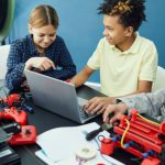 3D Printing - Cheerful group of teenagers using laptop