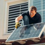 Photovoltaic Glass - Man with Gloves Holding Solar Panels on the Roof