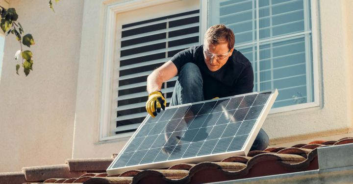 Photovoltaic Glass - Man with Gloves Holding Solar Panels on the Roof